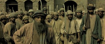 A group of men standing next to each other holding swords