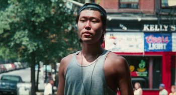 Movie still from “Kids” (1995), directed by Larry Clark – A man with headphones is standing on the street; Close Up shot, Low angle