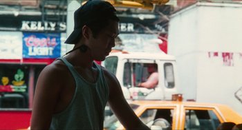 Movie still from “Kids” (1995), directed by Larry Clark – A young man wearing a baseball cap is riding a bike; Close Up shot, Over the shoulder angle