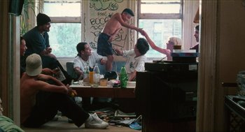 Movie still from “Kids” (1995), directed by Larry Clark – A group of young men sitting around a living room; Wide shot, High angle