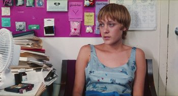 Movie still from “Kids” (1995), directed by Larry Clark – A woman sitting at a desk in front of papers; Medium shot, Over the shoulder angle