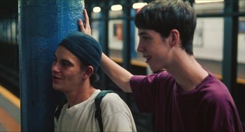 Movie still from “Kids” (1995), directed by Larry Clark – Two young men standing next to each other on a street; Medium shot, Over the shoulder angle