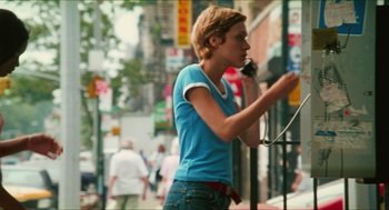 Movie still from “Kids” (1995), directed by Larry Clark – A young man talking on a cell phone on the street; Medium shot, Low angle