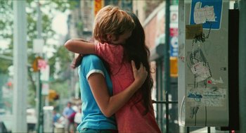 Movie still from “Kids” (1995), directed by Larry Clark – A couple of people that are hugging in the street; Medium shot, Over the shoulder angle
