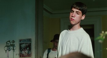 Movie still from “Kids” (1995), directed by Larry Clark – A young man standing in front of a mirror in a room; Medium shot, Low angle