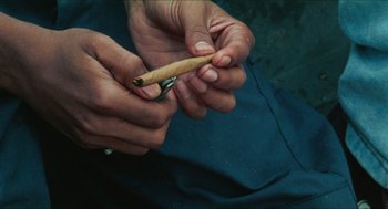 Movie still from “Kids” (1995), directed by Larry Clark – A person is holding a pair of scissors in their hands; Extreme Close Up shot, Overhead angle