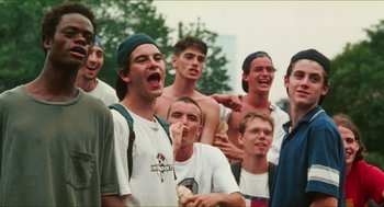 Movie still from “Kids” (1995), directed by Larry Clark – A group of young men standing next to each other; Medium shot, Low angle