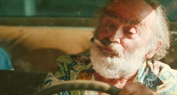 Movie still from “Kids” (1995), directed by Larry Clark – An old man with a beard smoking a cigarette; Close Up shot, Low angle