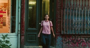 Movie still from “Kids” (1995), directed by Larry Clark – A woman in a pink shirt is standing in front of a building; Wide shot, Low angle