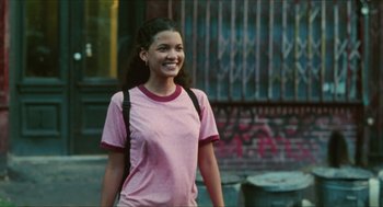 Movie still from “Kids” (1995), directed by Larry Clark – A young woman in a pink shirt is walking down the street; Medium shot, Low angle
