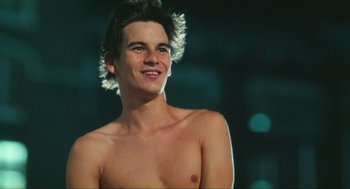 Movie still from “Kids” (1995), directed by Larry Clark – A young man with no shirt is posing for a picture; Close Up shot, Low angle