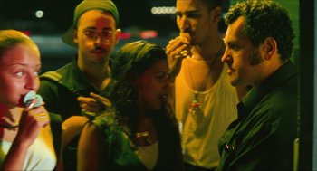 Movie still from “Kids” (1995), directed by Larry Clark – A group of people standing next to each other on a street; Medium shot, Over the shoulder angle