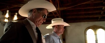 Movie still from “Kill Bill: Vol. 1” (2003), directed by Quentin Tarantino – Two men in cowboy hats are standing next to each other; Medium shot, Low angle