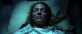 Movie still from “Kill Bill: Vol. 1” (2003), directed by Quentin Tarantino – A woman laying in a hospital bed with her eyes closed; Close Up shot, Overhead angle