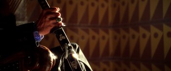 Movie still from “Kill Bill: Vol. 1” (2003), directed by Quentin Tarantino – A person holding a wine bottle in their hand; Extreme Close Up shot, Low angle