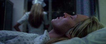 Movie still from “Kill Bill: Vol. 1” (2003), directed by Quentin Tarantino – A woman laying in a hospital bed with her eyes closed; Close Up shot, Low angle