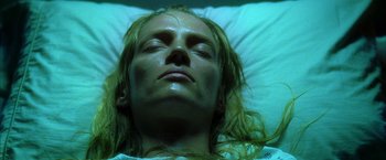 Movie still from “Kill Bill: Vol. 1” (2003), directed by Quentin Tarantino – A woman laying in a bed with her eyes closed; Close Up shot, Overhead angle