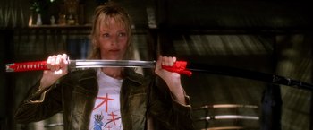 Movie still from “Kill Bill: Vol. 1” (2003), directed by Quentin Tarantino – A woman holding a sword in her hand; Close Up shot, Low angle