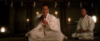 Movie still from “Kill Bill: Vol. 1” (2003), directed by Quentin Tarantino – A man sitting in a room with candles around him; Medium shot, Low angle