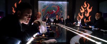 Movie still from “Kill Bill: Vol. 1” (2003), directed by Quentin Tarantino – A group of people sitting around a table with food on top of it; Medium shot, Over the shoulder angle