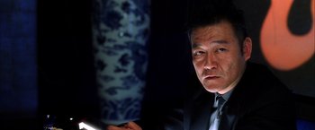 Movie still from “Kill Bill: Vol. 1” (2003), directed by Quentin Tarantino – A person wearing a suit and tie; Close Up shot, Low angle