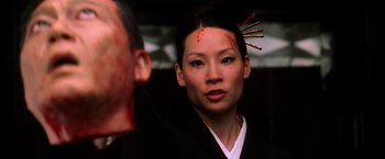 Movie still from “Kill Bill: Vol. 1” (2003), directed by Quentin Tarantino – A woman with makeup on her face and a man with a sword on his head; Close Up shot, Over the shoulder angle