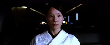 Movie still from “Kill Bill: Vol. 1” (2003), directed by Quentin Tarantino – A woman wearing a white kimono is looking at the camera; Close Up shot, Low angle