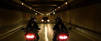 Movie still from “Kill Bill: Vol. 1” (2003), directed by Quentin Tarantino – A group of people riding motorcycles in a tunnel; Wide shot, High angle