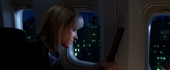 Movie still from “Kill Bill: Vol. 1” (2003), directed by Quentin Tarantino – A woman looking at her cell phone while sitting on an airplane at night; Close Up shot, Low angle