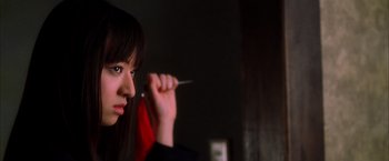 Movie still from “Kill Bill: Vol. 1” (2003), directed by Quentin Tarantino – A woman holding a pair of scissors in her hand; Close Up shot, Low angle