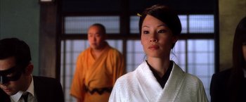 Movie still from “Kill Bill: Vol. 1” (2003), directed by Quentin Tarantino – A woman in a white robe standing in front of a man in a yellow robe; Close Up shot, Over the shoulder angle