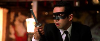 Movie still from “Kill Bill: Vol. 1” (2003), directed by Quentin Tarantino – A man in a suit and mask holding a sword; Close Up shot, Low angle