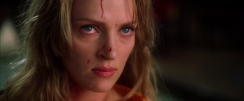Movie still from “Kill Bill: Vol. 1” (2003), directed by Quentin Tarantino – A person with blood on her face; Close Up shot, Low angle