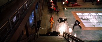 Movie still from “Kill Bill: Vol. 1” (2003), directed by Quentin Tarantino – A group of people in a room with tables and chairs; Extreme Wide shot, High angle