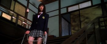 Movie still from “Kill Bill: Vol. 1” (2003), directed by Quentin Tarantino – A woman in a school uniform chained to a railing; Medium shot, Low angle