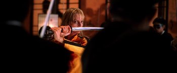 Movie still from “Kill Bill: Vol. 1” (2003), directed by Quentin Tarantino – A woman is holding a sword in her hand; Close Up shot, Low angle