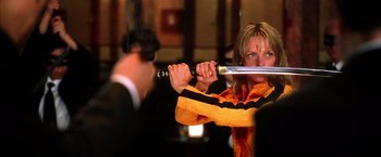 Movie still from “Kill Bill: Vol. 1” (2003), directed by Quentin Tarantino – A woman holding a baseball bat in her hands; Medium shot, Low angle