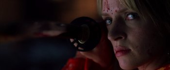 Movie still from “Kill Bill: Vol. 1” (2003), directed by Quentin Tarantino – A woman with blood all over her face looking into a mirror; Close Up shot, Low angle