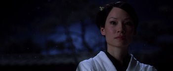 Movie still from “Kill Bill: Vol. 1” (2003), directed by Quentin Tarantino – A woman with a flower in her hair looking to her left; Close Up shot, Over the shoulder angle