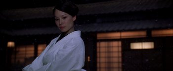 Movie still from “Kill Bill: Vol. 1” (2003), directed by Quentin Tarantino – A woman in a white robe standing in front of a building; Close Up shot, Low angle