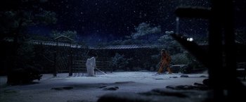 Movie still from “Kill Bill: Vol. 1” (2003), directed by Quentin Tarantino – A person is standing in the snow near a fence; Extreme Wide shot, High angle