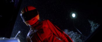 Movie still from “Kill Bill: Vol. 1” (2003), directed by Quentin Tarantino – A man in a red suit and helmet standing in front of the moon; Medium shot, Low angle