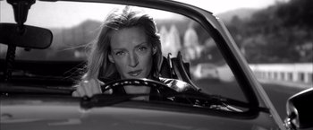 Movie still from “Kill Bill: Vol. 2” (2004), directed by Quentin Tarantino – A woman sitting in the driver's seat of a car; Close Up shot, Low angle