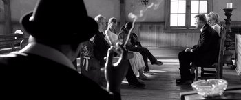 Movie still from “Kill Bill: Vol. 2” (2004), directed by Quentin Tarantino – A group of people sitting next to each other on a bench; Medium shot, Over the shoulder angle