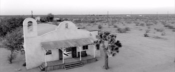 Movie still from “Kill Bill: Vol. 2” (2004), directed by Quentin Tarantino – An old western style building in the middle of a desert; Extreme Wide shot, High angle