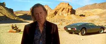 Movie still from “Kill Bill: Vol. 2” (2004), directed by Quentin Tarantino – A man standing next to a car in the desert; Medium shot, Low angle