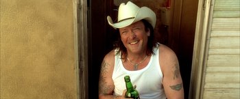 Movie still from “Kill Bill: Vol. 2” (2004), directed by Quentin Tarantino – A man in a white cowboy hat holding a beer; Close Up shot, Over the shoulder angle