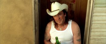 Movie still from “Kill Bill: Vol. 2” (2004), directed by Quentin Tarantino – A man in a white cowboy hat holding a beer; Close Up shot, Over the shoulder angle