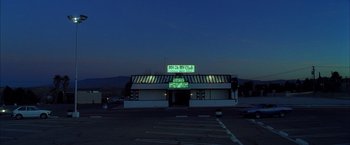 Movie still from “Kill Bill: Vol. 2” (2004), directed by Quentin Tarantino – An empty parking lot at night in front of an empty building; Extreme Wide shot, Low angle