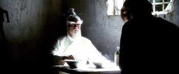 Movie still from “Kill Bill: Vol. 2” (2004), directed by Quentin Tarantino – An old man sitting at a table with two bowls of food; Medium shot, Over the shoulder angle